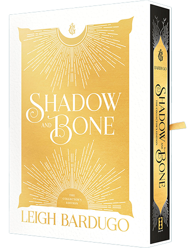 A gold and white cover design of the book "shadow and bone" by leigh bardugo, featuring ornamental patterns and a central emblem, displayed with its spine view.